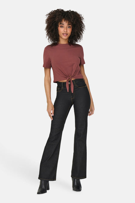 Bruin T-shirt met korte mouwen van ONLY, met knoop aan de voorkant, gedragen met een high-waisted jeans en zwarte enkellaarsjes.