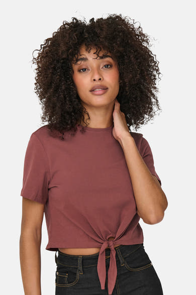 T-shirt à manches courtes brun de ONLY, avec un nœud décoratif et porté avec un jean.
