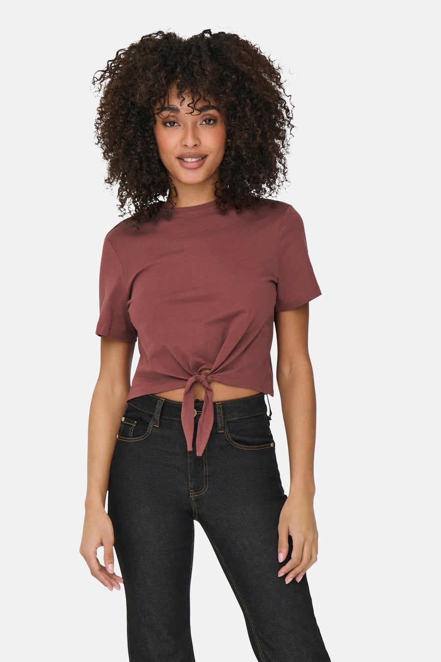 T-shirt à manches courtes brun de ONLY®, noué devant, porté avec un jean foncé.
