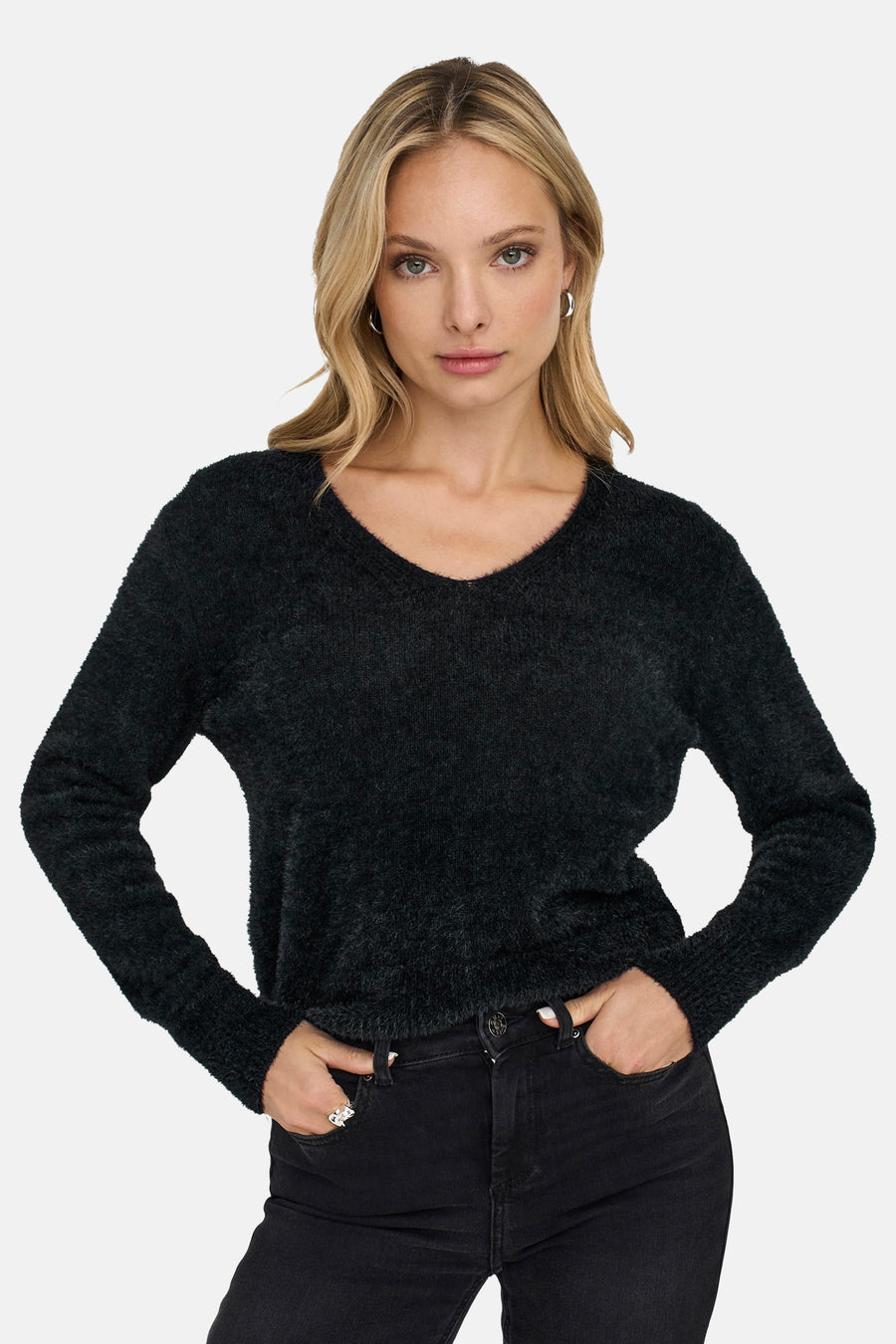 Pull noir à col rond de ONLY, porté avec un jean noir et des boucles d'oreilles argentées.