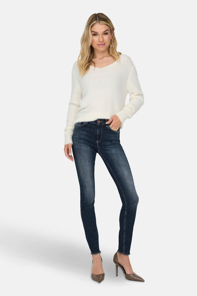 Pull à col rond blanc de ONLY®, porté avec un jean foncé et des escarpins à talons aiguilles.
