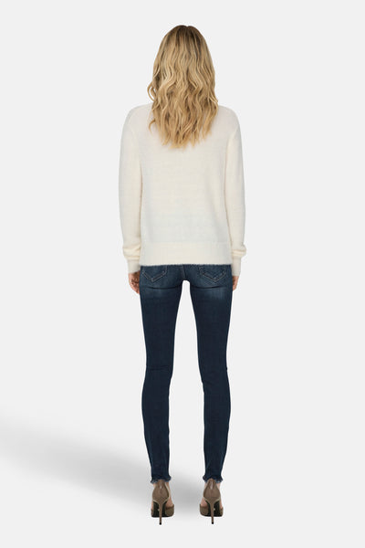 Pull à col rond blanc de ONLY®, porté avec un jean slim et des chaussures à talons.
