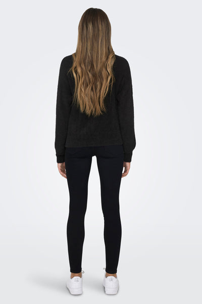 Gilet noir par ONLY, style décontracté, avec une texture douce, porté avec un pantalon noir et des chaussures de sport blanches.