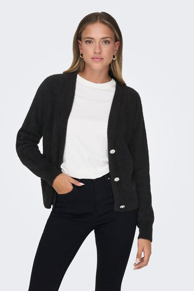 Gilet noir par ONLY, porté sur un t-shirt blanc uni et un jean noir moulant, avec boutons décoratifs.
