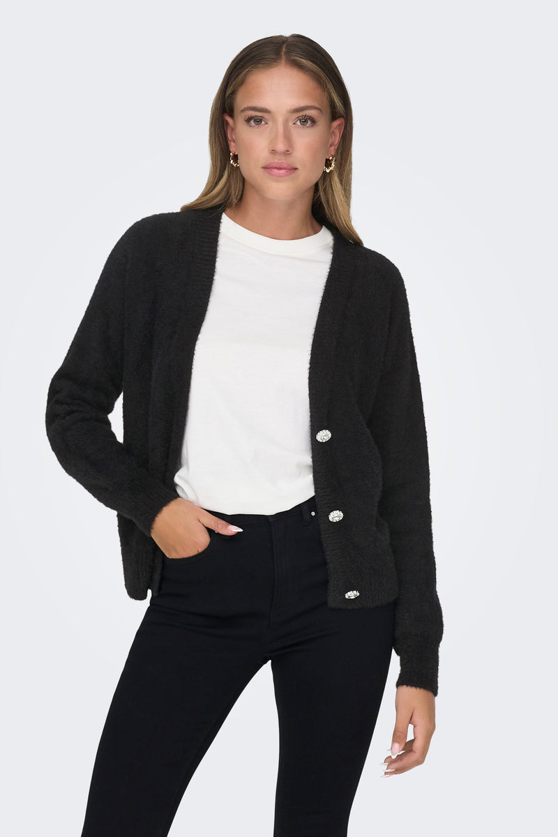 Gilet noir par ONLY, porté sur un t-shirt blanc uni et un jean noir moulant, avec boutons décoratifs.
