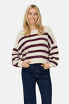 Pull à col rond écru by ONLY, à rayures bordeaux, porté avec un jean bleu foncé.
