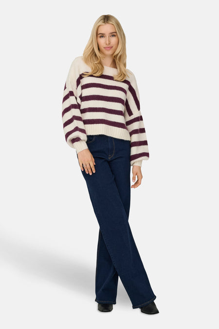 Ecru ronde hals trui van ONLY®, bordeaux gestreept, gedragen met een donkerblauwe jeans.