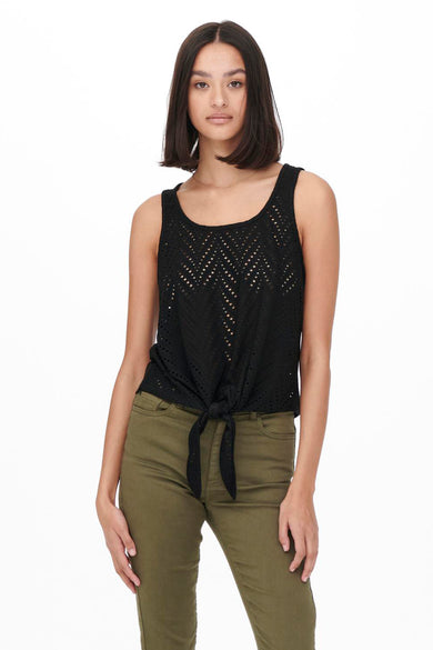 Black sleeveless top with eyelet pattern and front knot detail, worn with olive green pants, front view