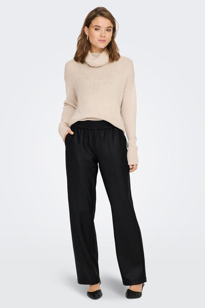 Pantalon noir de ONLY, avec une taille élastique, porté avec un pull à col roulé beige.