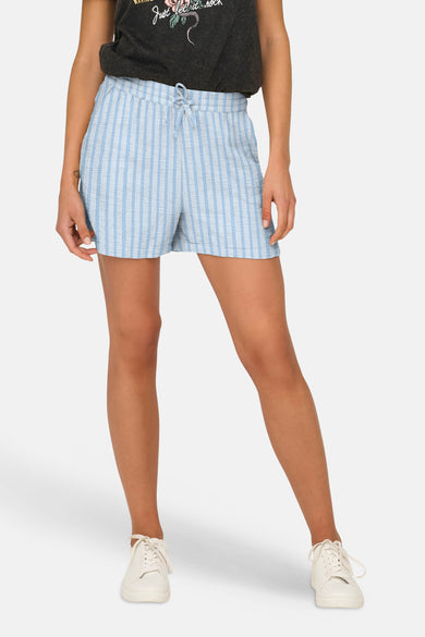 Short rayé bleu et blanc de ONLY® avec taille élastiquée, porté avec un t-shirt foncé et des baskets blanches.