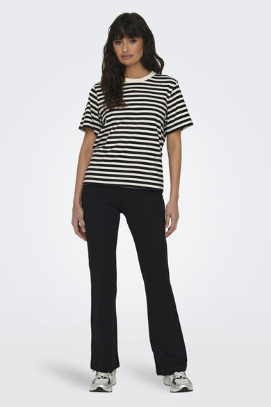 T-shirt à rayures noir et blanc de ONLY, porté avec un pantalon noir et des chaussures de sport.
