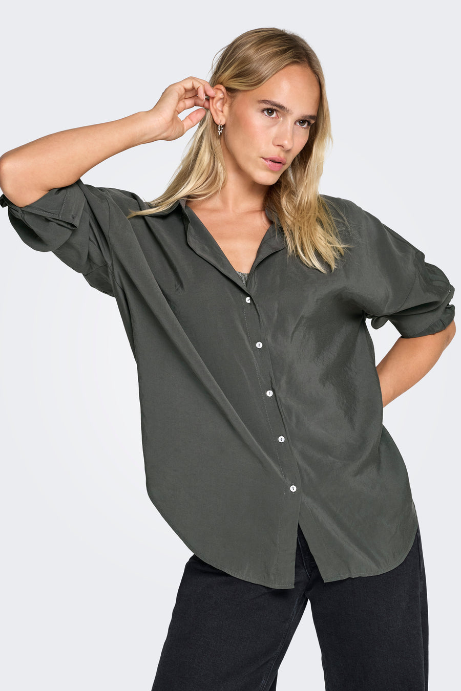 Chemisier à manches longues gris de ONLY, avec boutons blancs et porté avec un jean noir.
