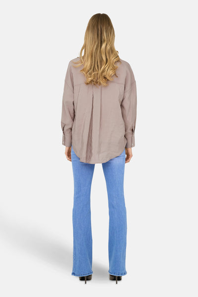 Beige chemisier met lange mouwen van ONLY, met een ruime en ontspannen stijl, gedragen met een blauwe jeans.