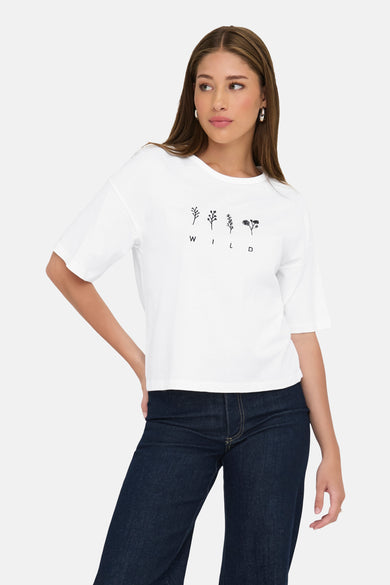 Wit T-shirt met korte mouwen van JDY, met bloemenprint en zwarte letters, gedragen met een donkere spijkerbroek.