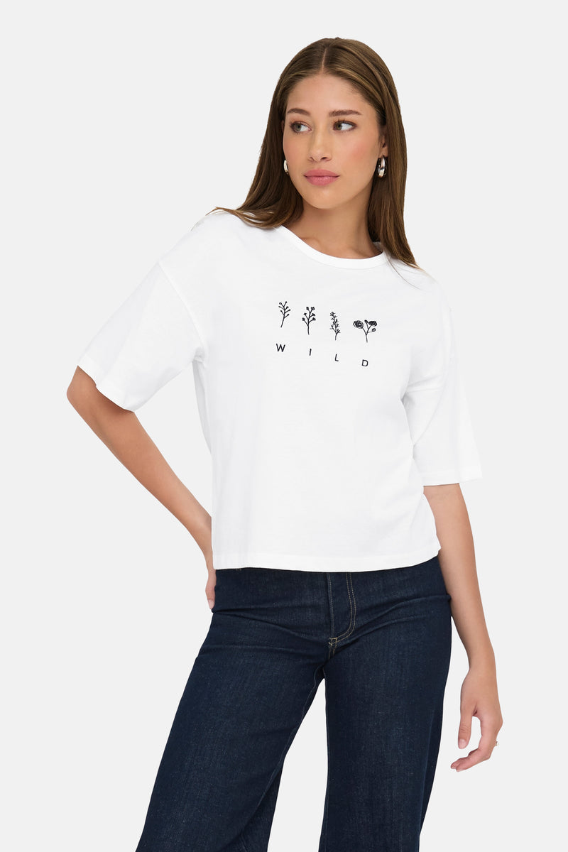 Wit T-shirt met korte mouwen van JDY, met bloemenprint en zwarte letters, gedragen met een donkere spijkerbroek.