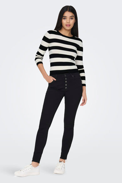 Pull noir de JDY à rayures horizontales blanches, porté avec un pantalon taille haute noir et des baskets blanches.
