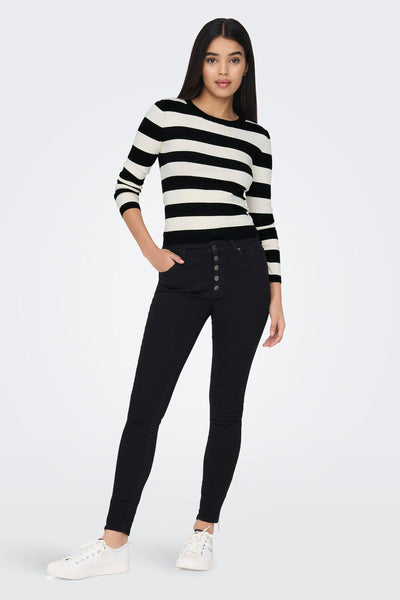 Pull noir de JDY à rayures horizontales blanches, porté avec un pantalon taille haute noir et des baskets blanches.