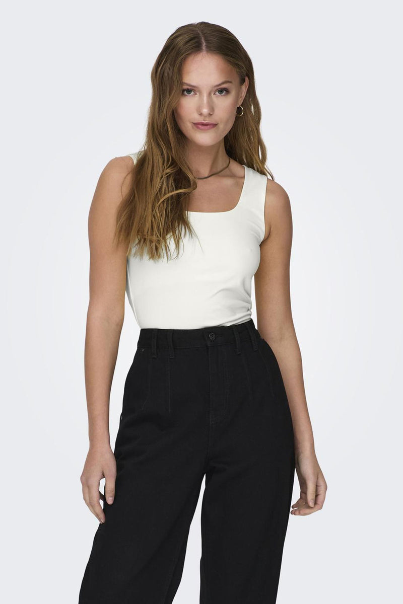 Top écru de ONLY, porté avec un pantalon taille haute noir et un collier fin doré