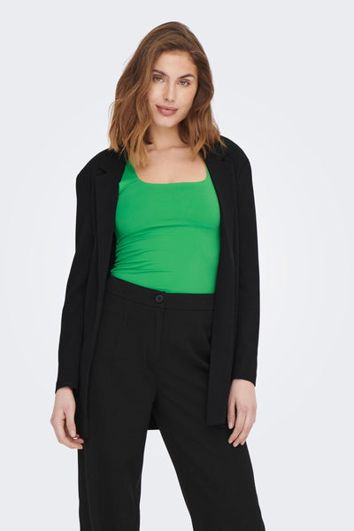 Groen topje met dunne bandjes van ONLY, gedragen onder een zwart colbert, met een zwarte broek met hoge taille.