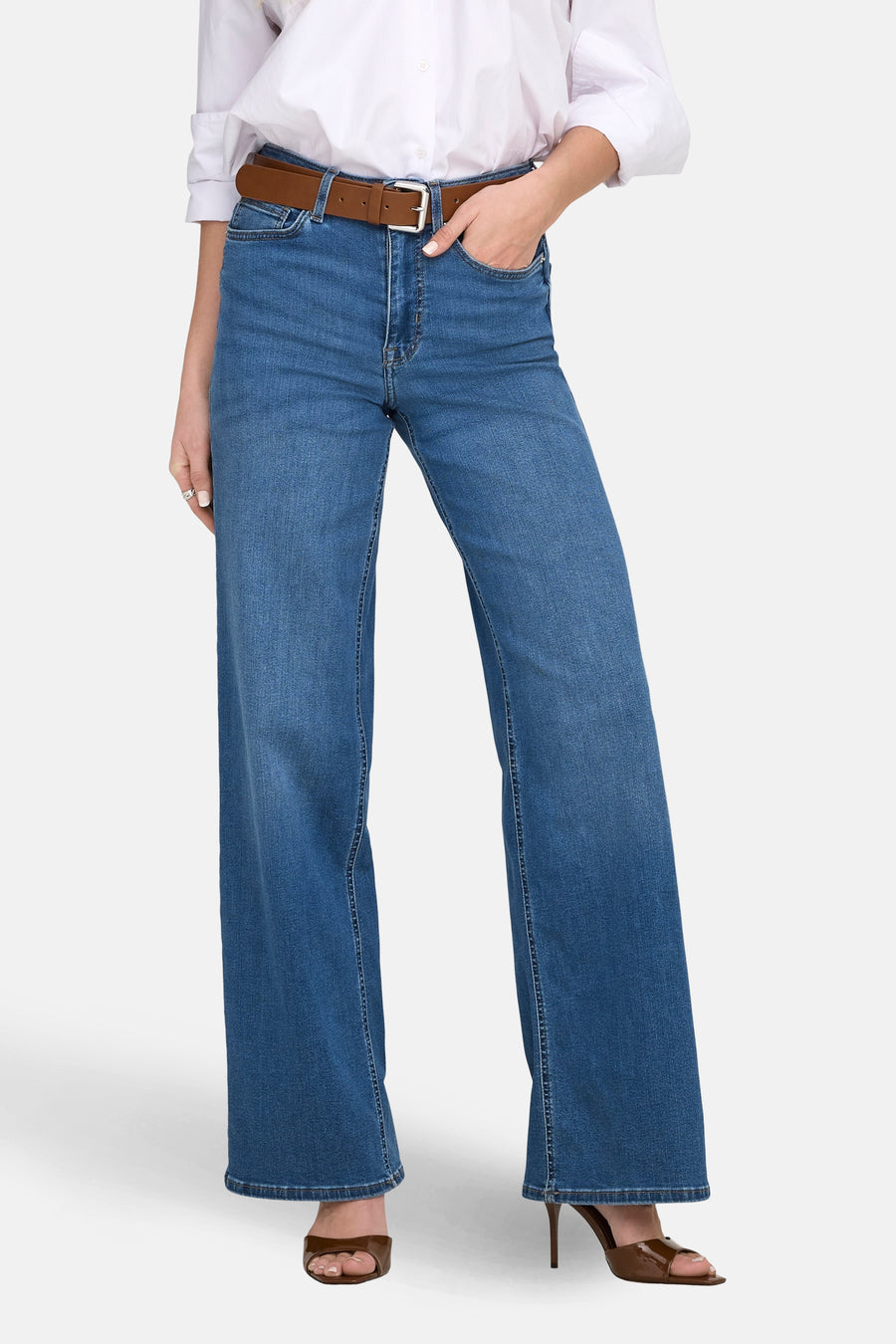 Jeans larges en denim bleu moyen de ONLY, portés avec une ceinture marron et des chaussures à talons.
