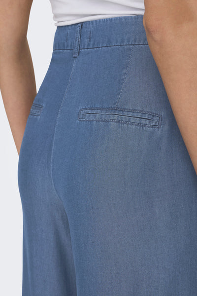 Pantalon bleu denim mi-long par JDY, avec poches arrière passepoilées et passants de ceinture.