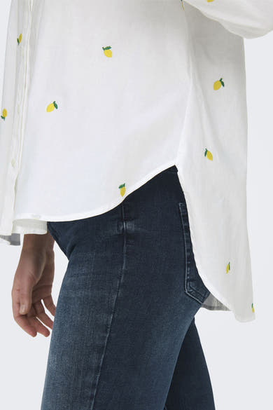 Chemisier à manches longues blanc de ONLY, avec motif citron brodé, porté avec un jean.