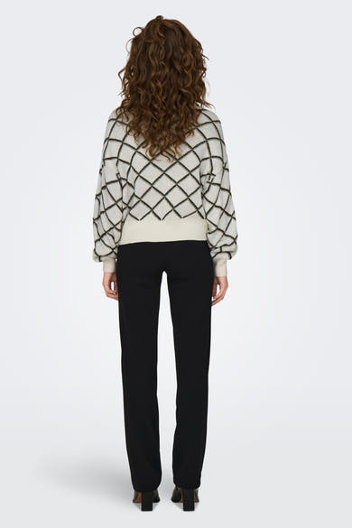 Pull à col rond écru de JDY avec motif à losanges noirs, porté avec un pantalon noir.