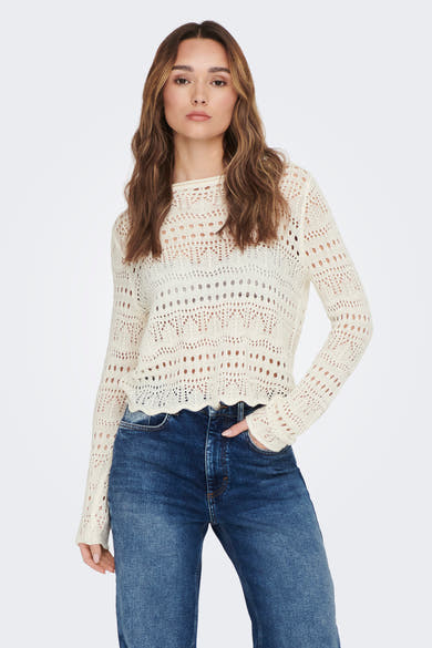 Pull à col rond blanc de JDY avec motif ajouré, porté avec un jean taille haute.
