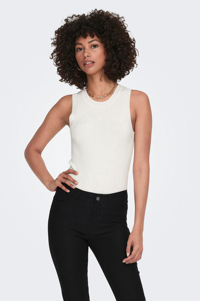 Top sans manches blanc de JDY avec une texture côtelée, porté avec un jean noir.

