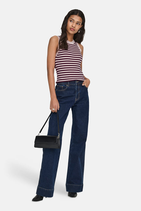 Top sans manches rayé multicolore de JDY en maille côtelée rose pâle et bordeaux, porté avec un jean bleu et un sac noir.
