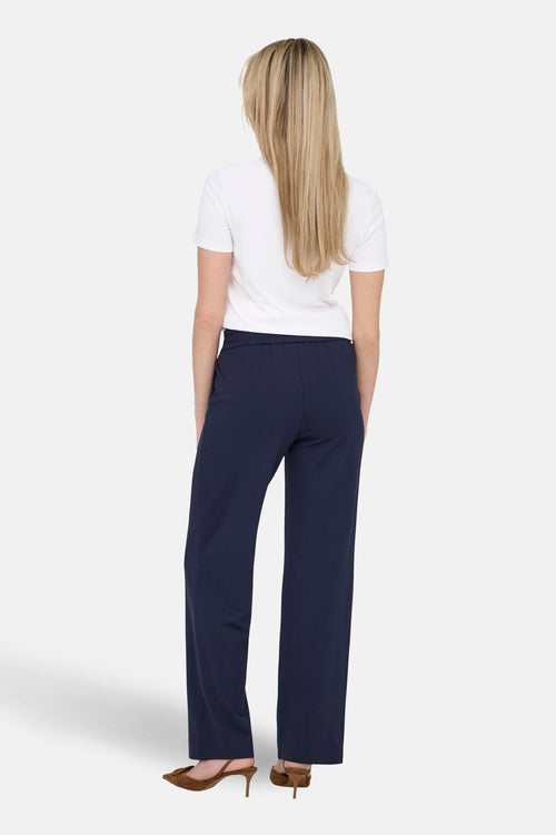 T-shirt à manches courtes blanc par ONLY, porté avec un pantalon marine et des chaussures à talons marron.
