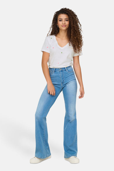 Wit T-shirt met bloemenborduursel van ONLY®, gedragen met een lichtblauwe flared jeans.