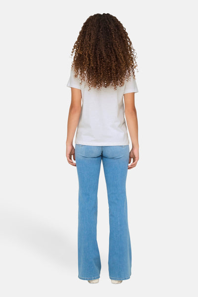 Wit T-shirt van ONLY, gedragen met een high-waisted spijkerbroek, van achteren gezien, met bruin krullend haar.
