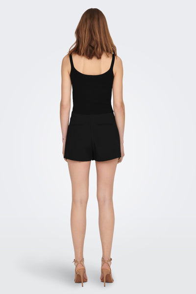 Black ribbed sleeveless top back view with scoop neckline and fitted silhouette, worn with black shorts and tan heels