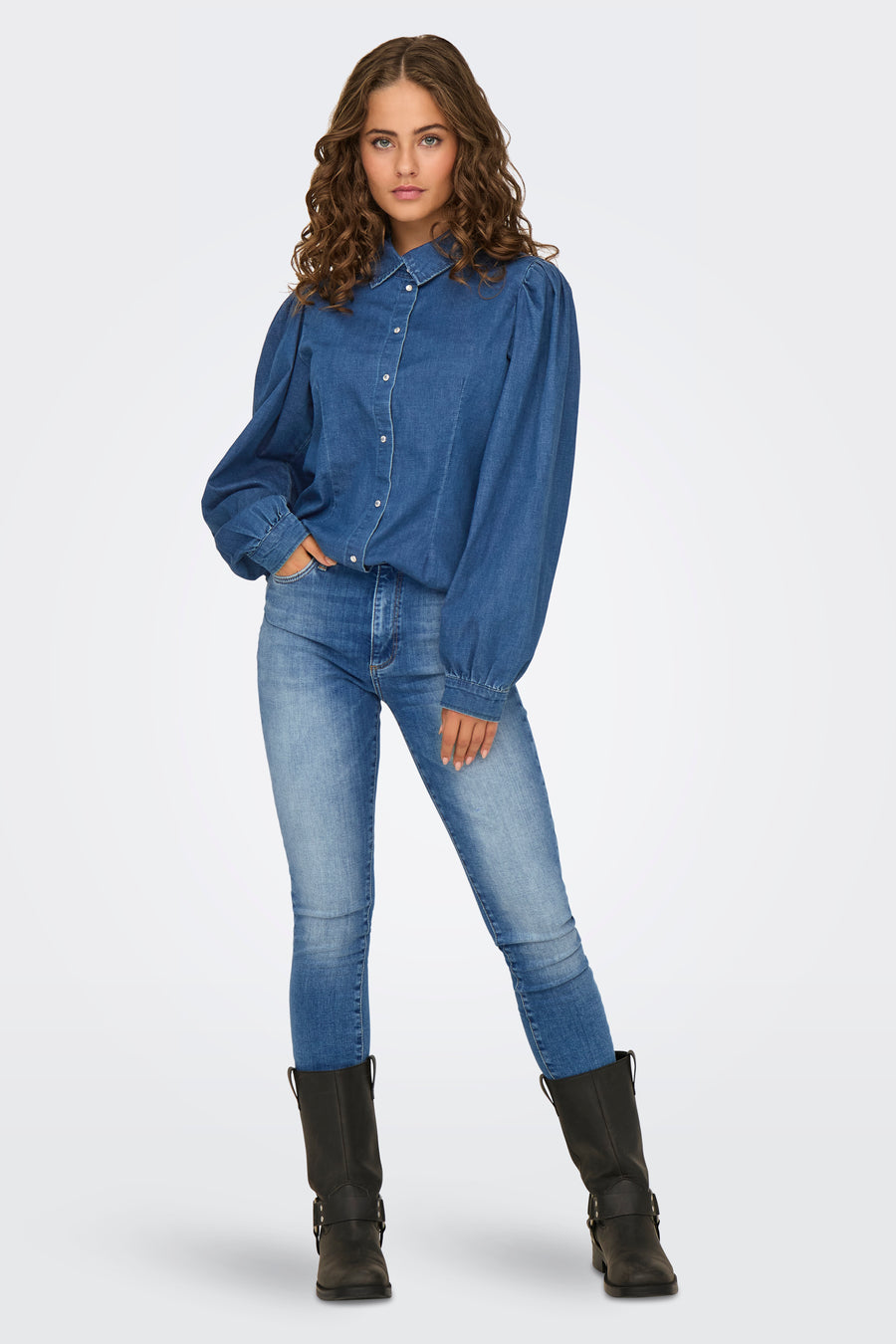 Donkerblauwe skinny jeans van ONLY, gedragen met een spijkerblouse en zwarte laarzen.