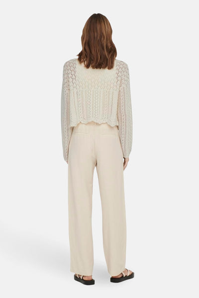 Ecru gebreid vest met open structuur van ONLY, gedragen met een beige broek met hoge taille en zwarte sandalen, achtergezicht.