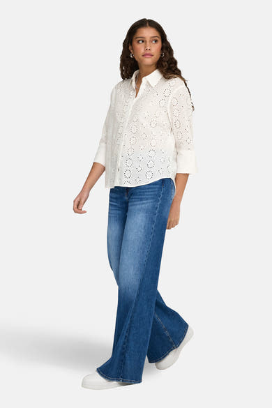Wit overhemd met lange mouwen van JDY, met geborduurde details en gedragen met een wijde jeans en witte sneakers.