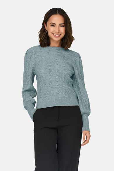 Pull bleu à col rond de ONLY®, en maille texturée, porté avec un pantalon noir.
