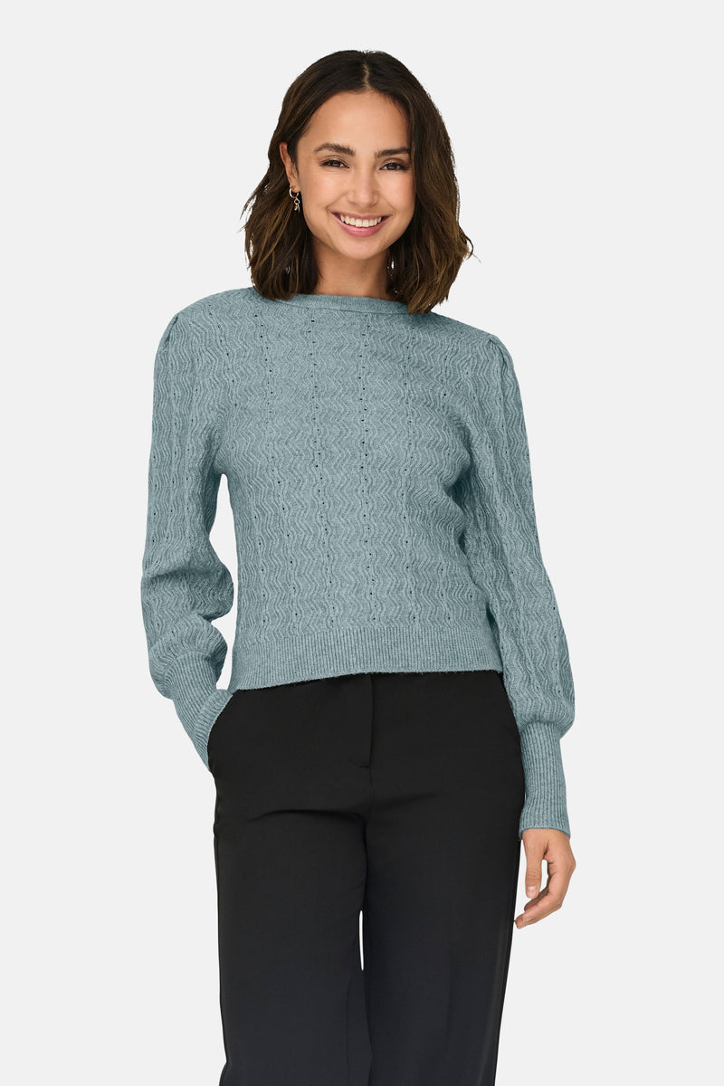 Pull bleu à col rond de ONLY®, en maille texturée, porté avec un pantalon noir.
