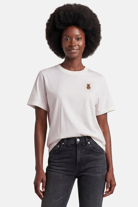 T-shirt blanc de JDY avec broderie ours en peluche sur la poitrine, porté par une femme en jean foncé.