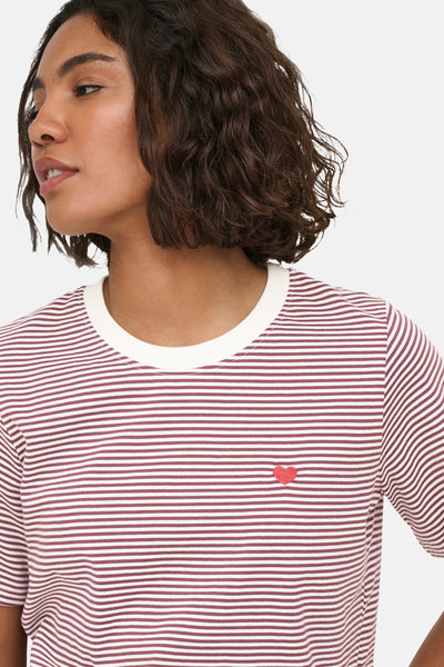 Burgundy and white striped short-sleeve t-shirt with red heart embroidery, side view of model wearing it