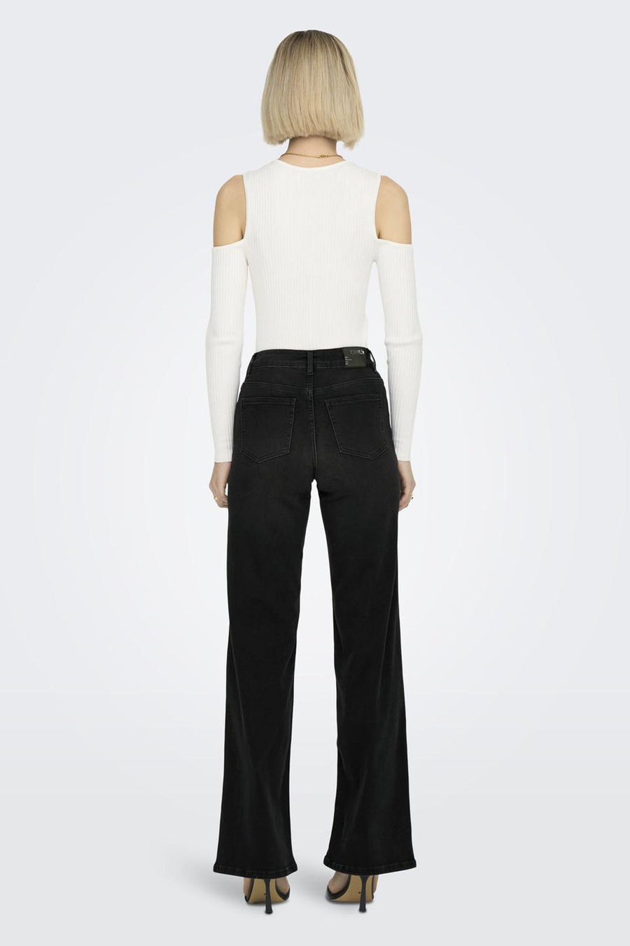 Jean large noir de ONLY, avec coupe droite et taille haute, porté avec un haut blanc.