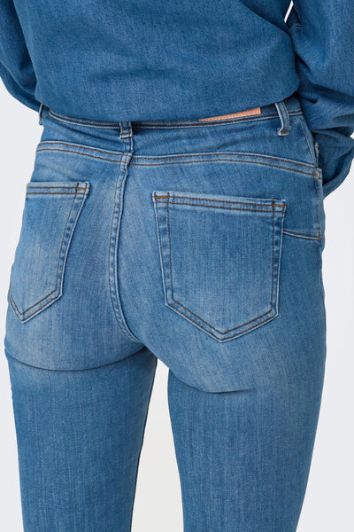 Blue skinny jeans with faded wash and brown stitching, back view showing two pockets and slim fit leg.