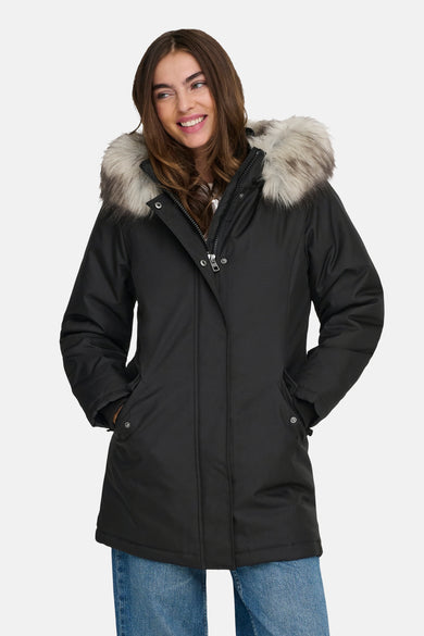 Veste longue noire de ONLY, avec capuche bordée de fourrure, portée sur un jean bleu.
