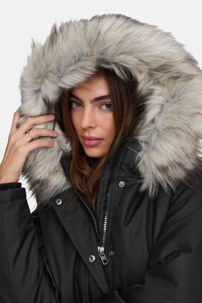 Veste longue noire de ONLY, avec capuche bordée de fourrure synthétique et fermeture à glissière apparente.
