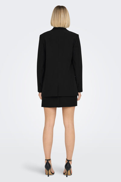 Blazer noir de ONLY®, porté avec une jupe noire et des talons hauts noirs, vue de dos.
