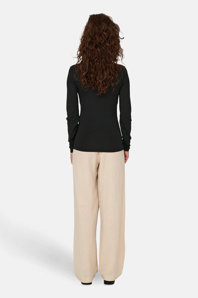 Zwarte T-shirt met lange mouwen van ONLY®, gedragen met een losse beige broek, achtergezicht.