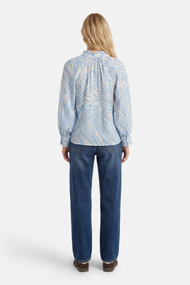 Chemisier à manches longues blanc et bleu de GOA GOA, à motif de feuilles, col froncé, porté avec un jean, vue de dos.