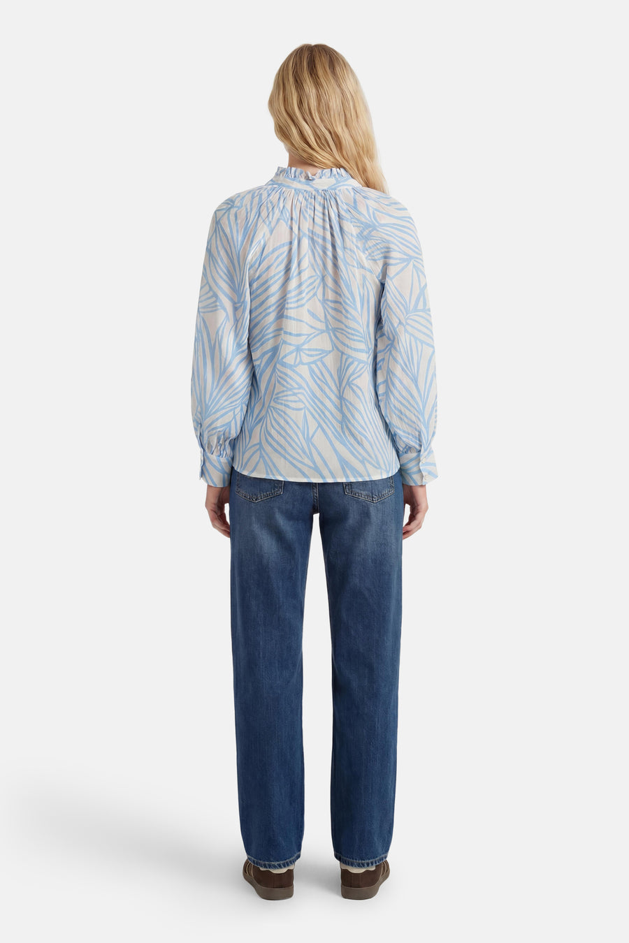 Chemisier à manches longues blanc et bleu de GOA GOA, à motif de feuilles, col froncé, porté avec un jean, vue de dos.