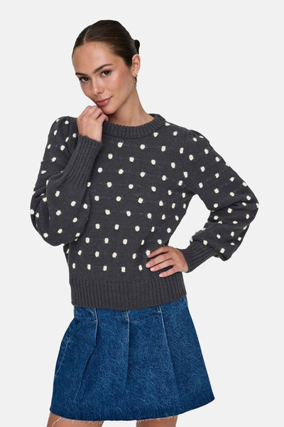 Pull gris à col rond de JDY, à motif à pois blancs, porté avec une jupe en denim.